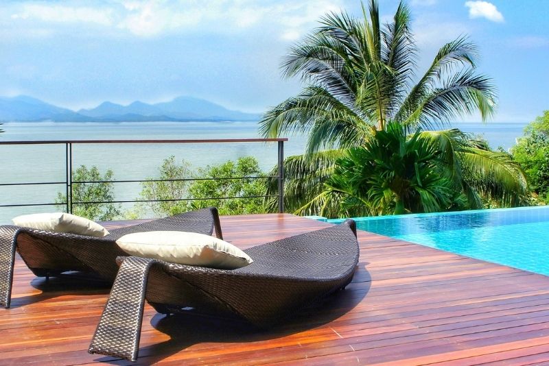 a relaxing swimming pool decking area with pool loungers