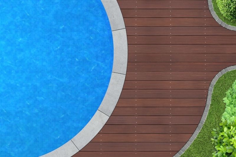 Aerial view of a curved timber deck bordering an in-ground pool