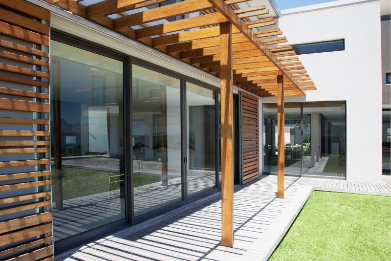 A pergola that is attached to a house