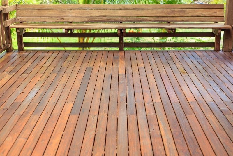 Stained timber decking with a built-in bench overlooking a garden